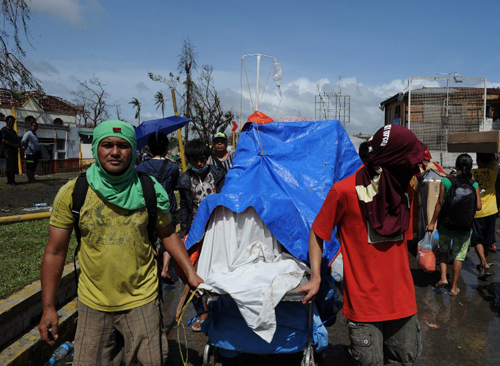 [Caption]&nbsp;Residents push an improvised trolley loaded with an injured relative as they head for a medical station in Tacloban City, Leyte province,central Philippines on November 10, 2013, three days after devastating Typhoon Haiyan hit the city on November 8.